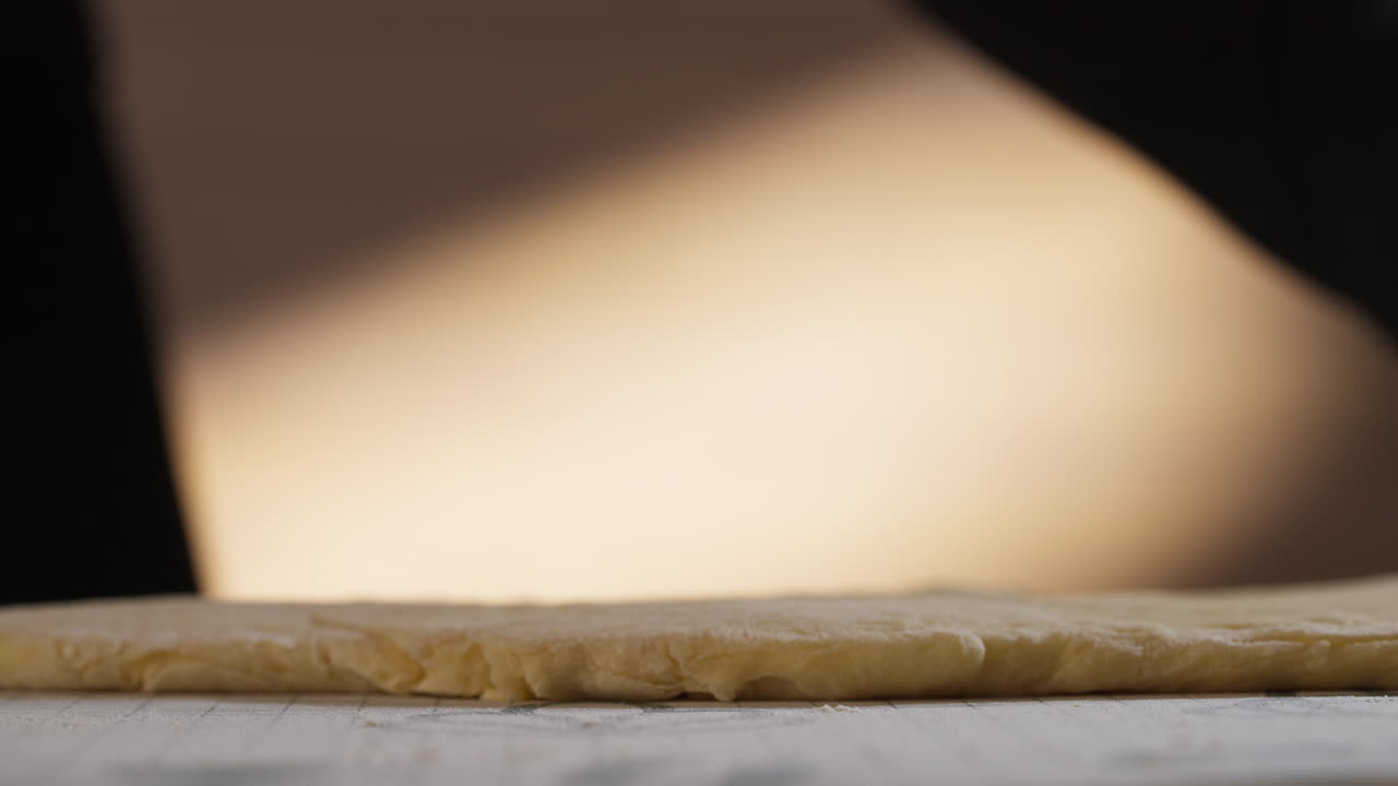 Dough Getting Rolled Out By Patissier With Rolling Pin. - closeup shot