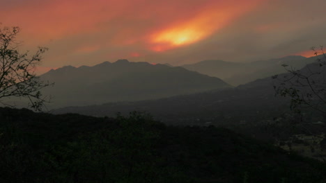 Las-Nubes-Ruedan-Sobre-Una-Cordillera-En-Un-Lapso-De-Tiempo-Con-Neblina,-Smog-Y-Humo-De-Un-Incendio-Forestal-En-El-Aire