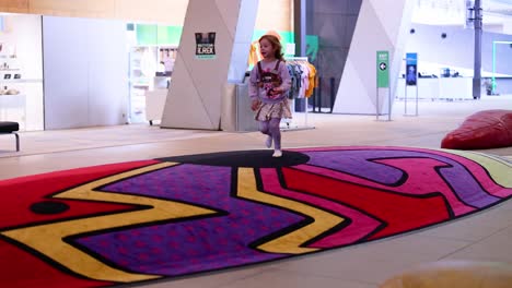 a child joyfully runs inside the museum