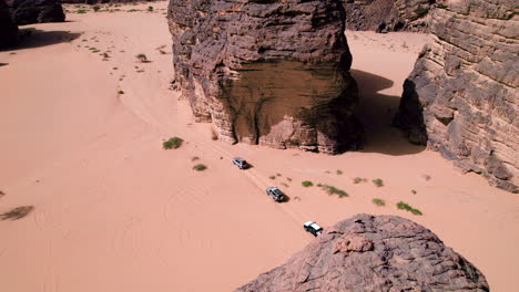 aerial view of cars driving across sahara desert in tassili n'ajjer national park, algeria