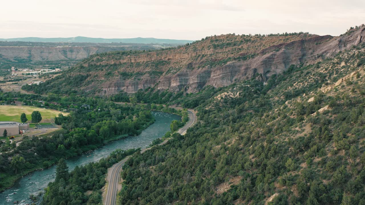 Sweeping shot moving upstream with the early light catching the ripples and cliffs on either side.