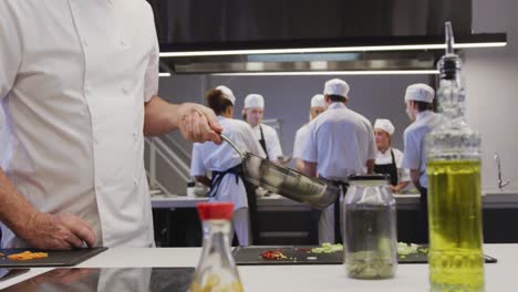 Chef-Masculino-Caucásico-Profesional-En-La-Cocina-De-Un-Restaurante-Preparando-Comida-Usando-Una-Sartén
