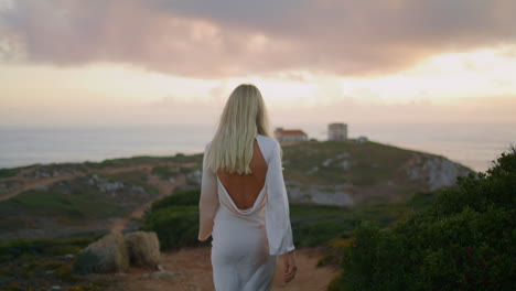 flirting blonde walking castle landscape closeup. sensual woman looking camera