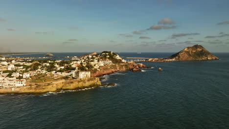 aerial tracking shot in front of the cityscape of mazatlan, golden hour in mexico