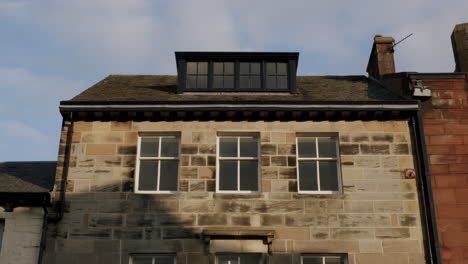 stone house with roof and windows on sunny day in town