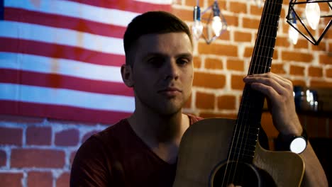 handsome young guitarist looking at camera