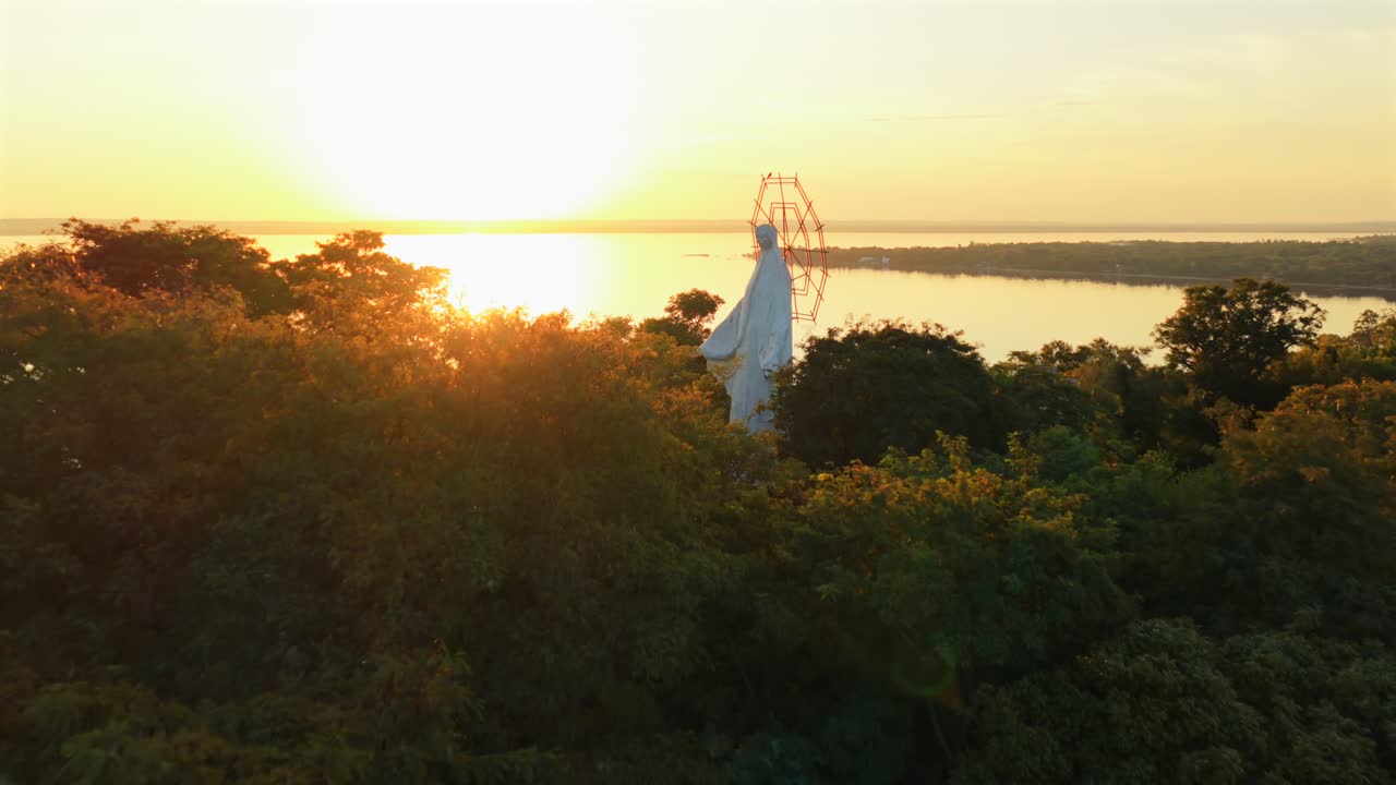 Stunning aerial footage captures the serene sunrise over lush forests in San Bernardino, Paraguay. The soft morning light creates a peaceful, golden ambiance with silhouettes against the sky