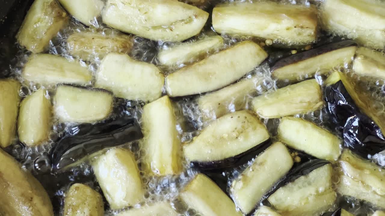 berenjenas vegetarianas fritas en una sartén en aceite vegetal