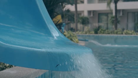 transparent water runs on slide against blurred pump