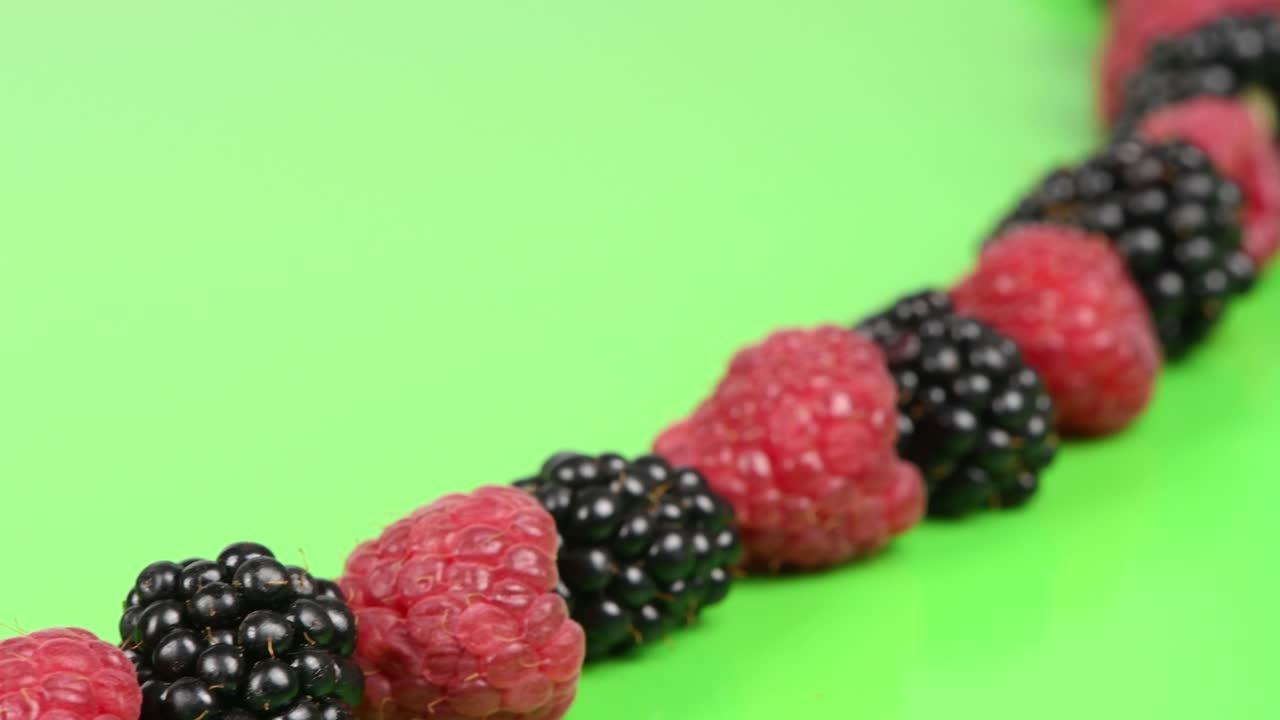 초록색 바탕에 검은색 라즈베리와 번갈아가며 아래 왼쪽 구석에서 오른쪽 상단 구석으로 움직입니다.