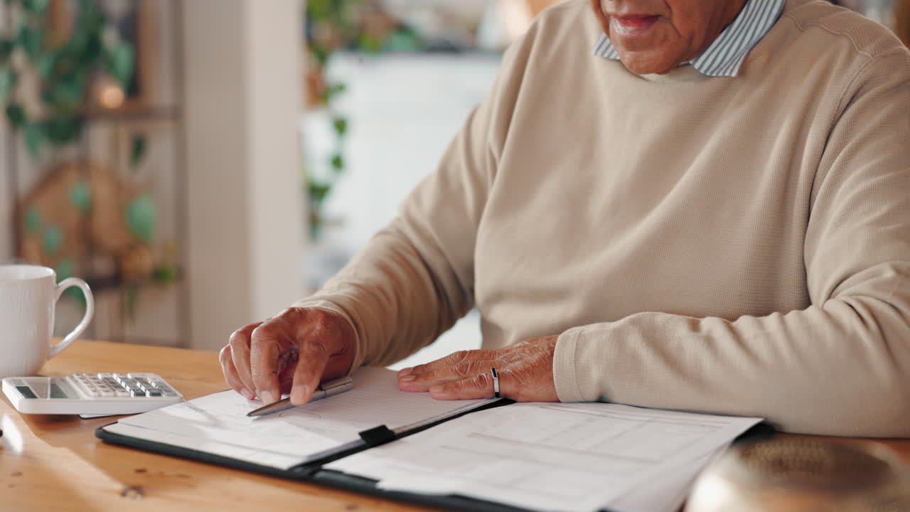 hombre mayor trabajando con una calculadora y un cuaderno