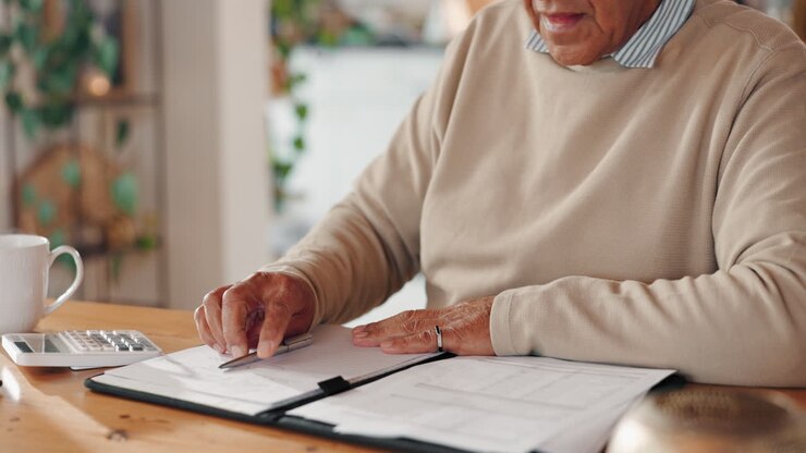Senior man working with a calculator and notebook