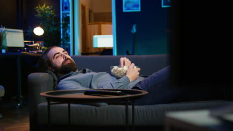 upbeat homeowner laying down on couch watching feel good movies on tv