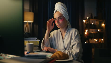 bata de baño freelance leyendo pc en primer plano en casa. mujer seria viendo computadora