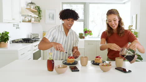diverse couple enjoying breakfast, sharing pancakes with fresh berries in modern kitchen, at home