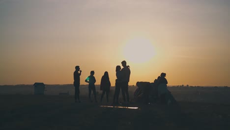 Siluetas-De-Turistas-Que-Pasan-Tiempo-En-Una-Tienda-De-Campaña-Al-Atardecer