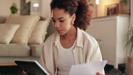 Woman working on a tablet and documents at home