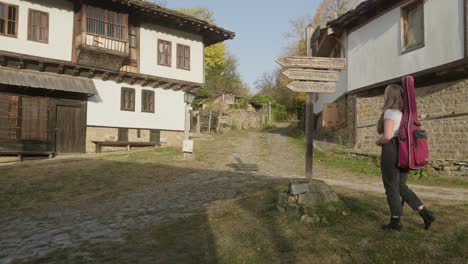 Young-woman-musician-read-traditional-village-direction-finger-post