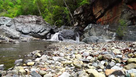 pequeña cascada, cayendo en cascada en un arroyo, rodeada de rocas en costa rica