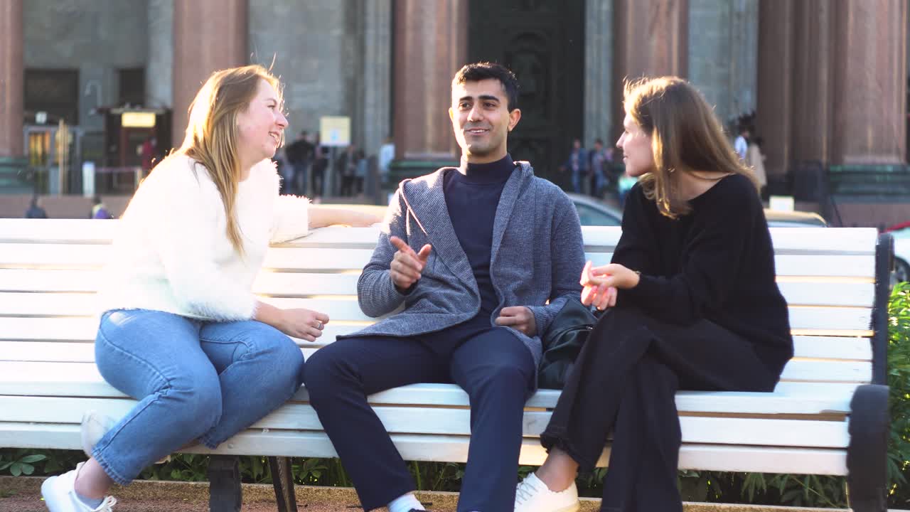 grupo de amigos charlando en un banco del parque en la ciudad