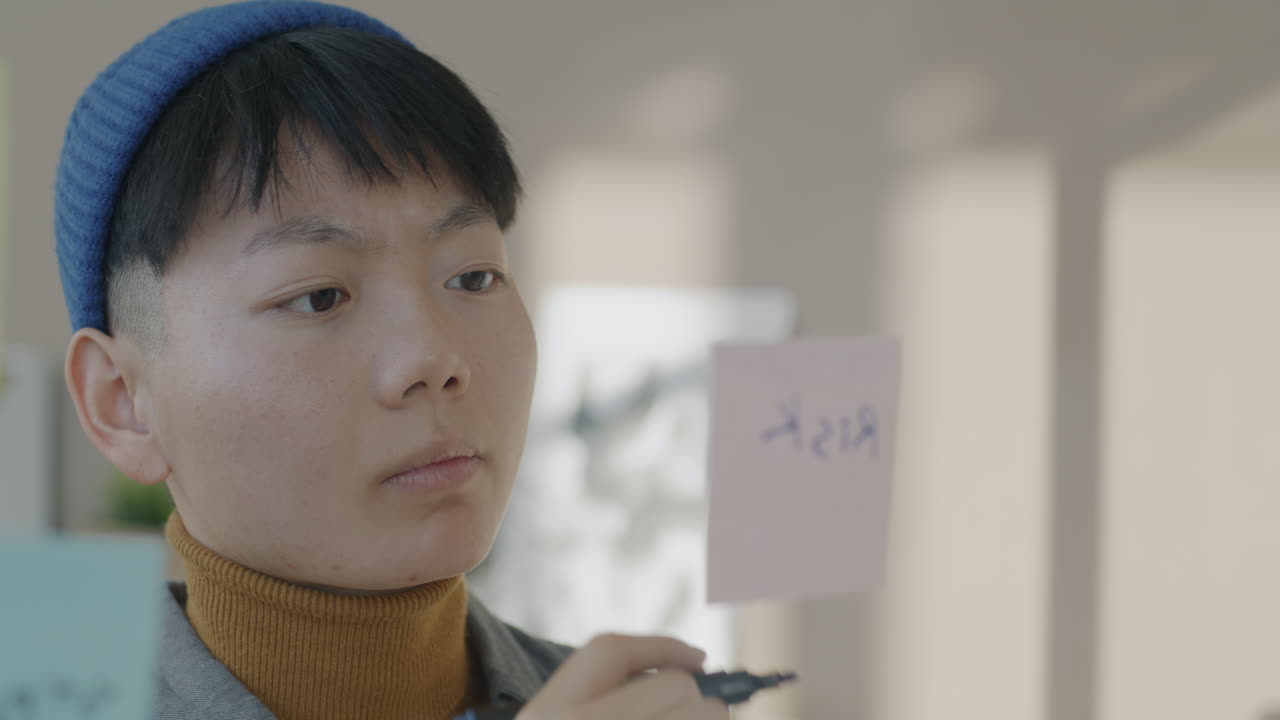 Young Person Writing on Sticky Note