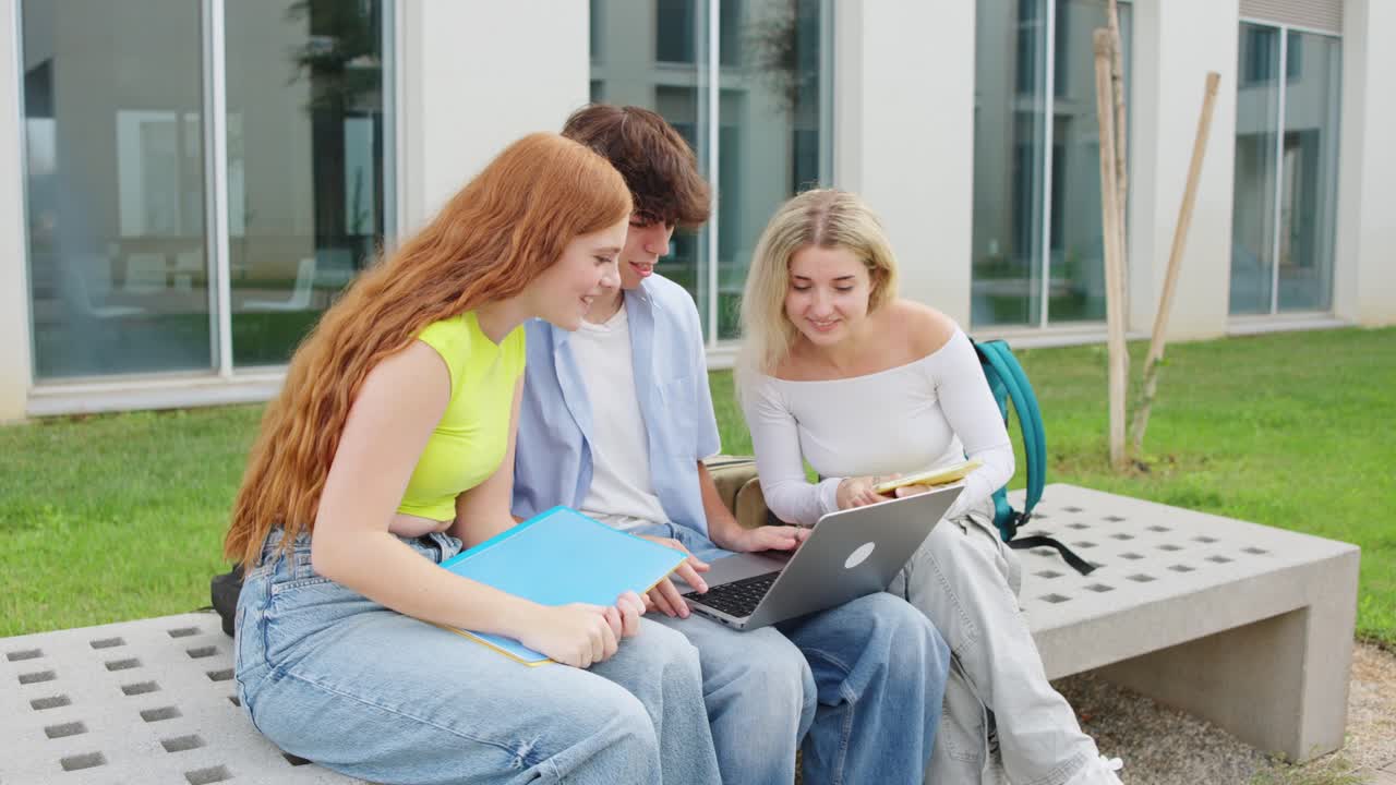 Group of students celebrating success while working on a laptop