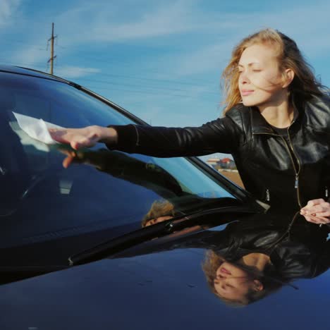 a young woman washes her car in a self-service sink 1