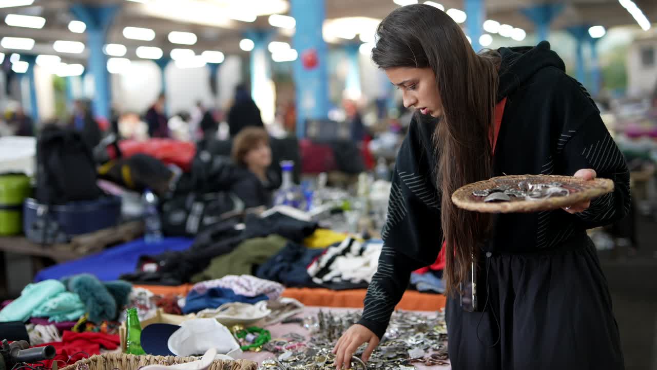 mujer revisando joyas en un mercado de pulgas