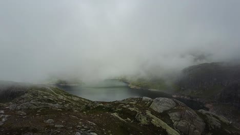levantándose en unas montañas malhumoradas, mostrando un lago y un paisaje brumoso