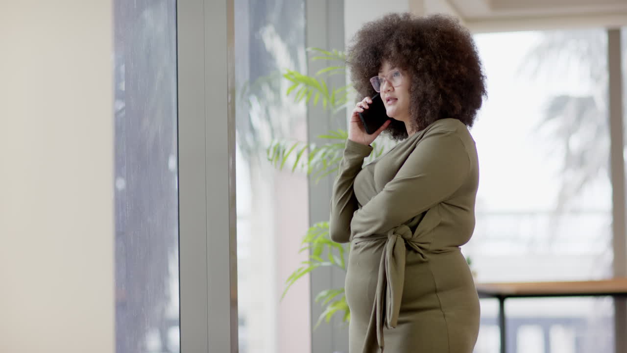 Donna d'affari birazziale in abbigliamento casual che usa lo smartphone in ufficio, slow motion con spazio per il testo