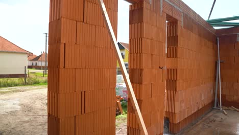 brick wall with window and door openings under construction on suburban street