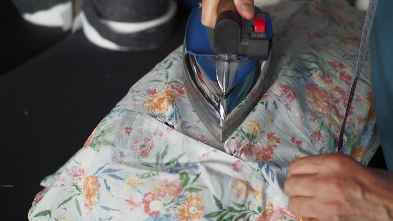 Close-up of Hands Sewing Floral Fabric