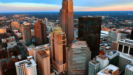 facades of beautiful skyscrapers in the orange light of sunset. distancing from high-rise building in charlotte, north carolina, usa