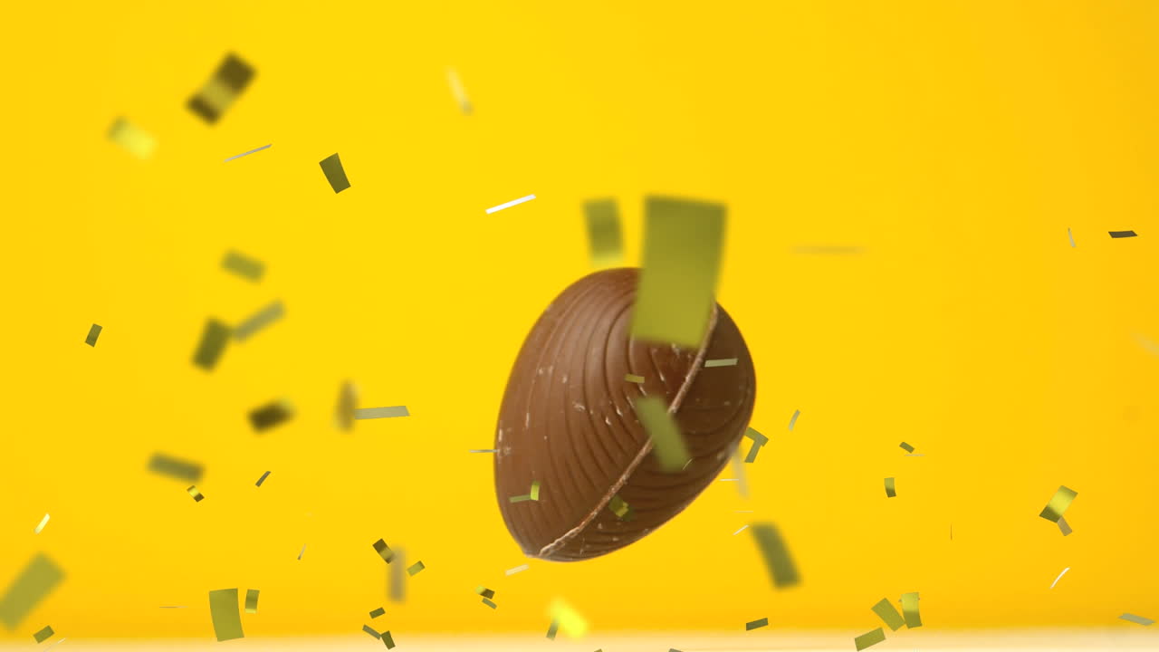Animation af guldkonfetti og chokolade påskeæg, der falder og hopper på gul baggrund