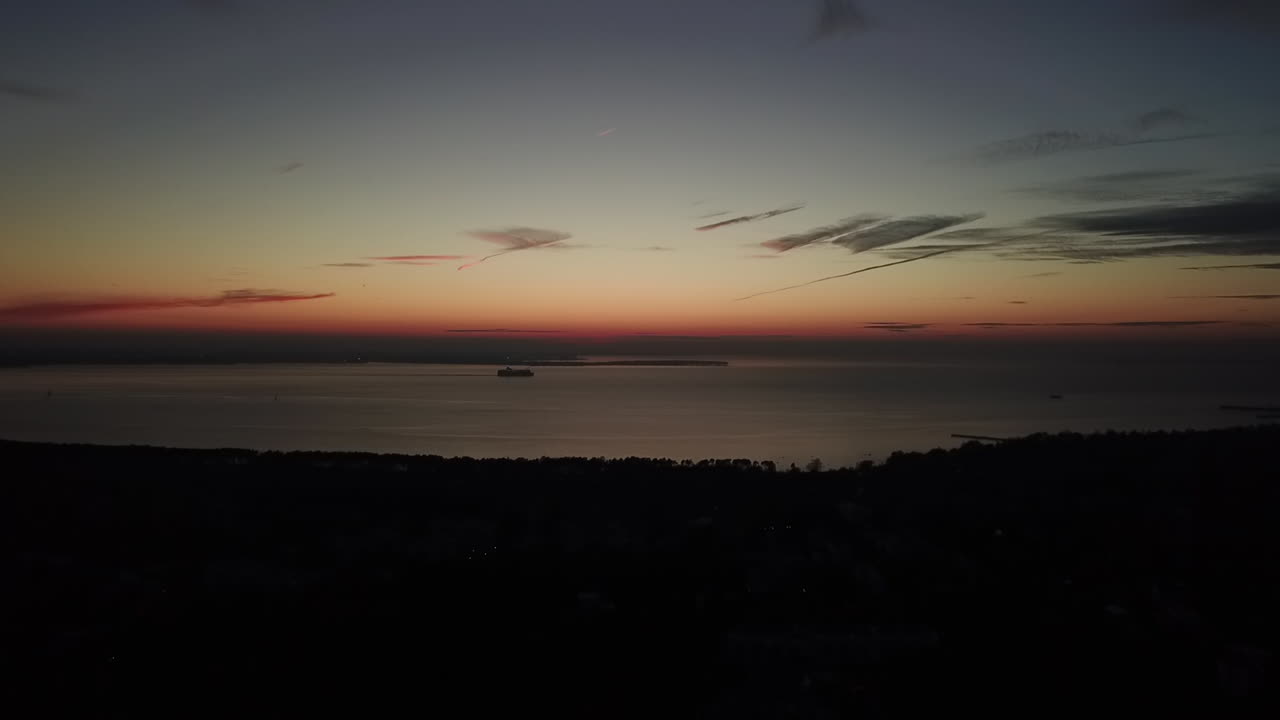 A ship moving on the ocean coastline on the evening