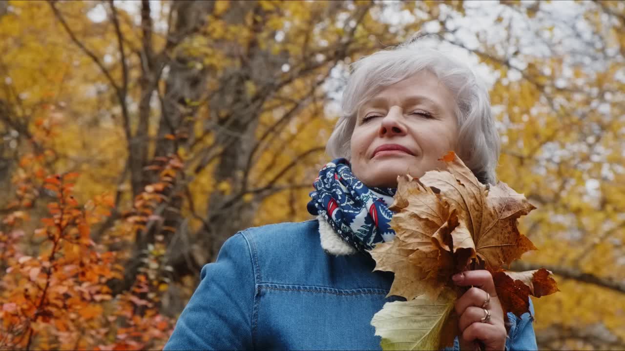 Senior Woman Enjoying Autumn Leaves