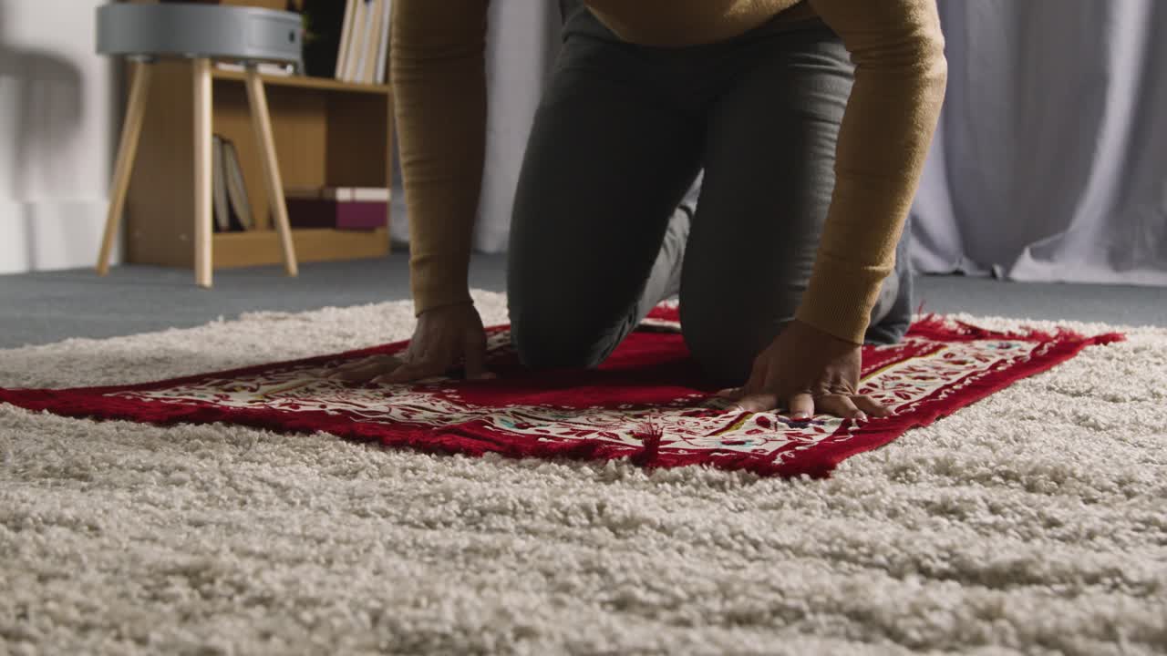 Muslim Man At Home Kneeling On Prayer Mat And Praying