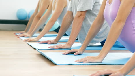 Clase-De-Yoga-Acostada-Sobre-Colchonetas-Haciendo-Postura-De-Cobra