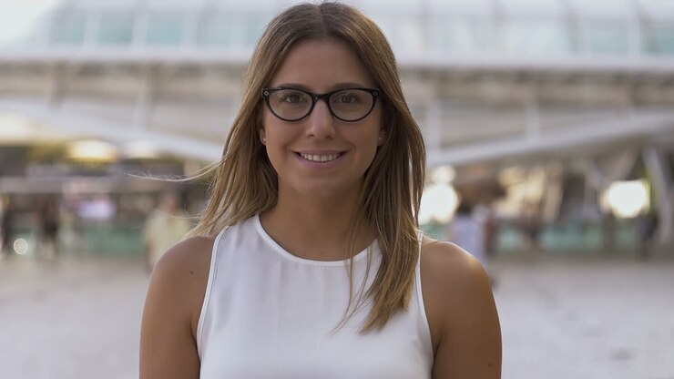 Bella giovane donna che sorride alla macchina fotografica all'aperto