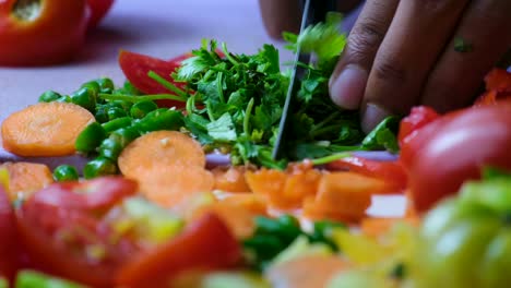 primer plano de un hombre cortando cilantro a mano trabajando en un restaurante