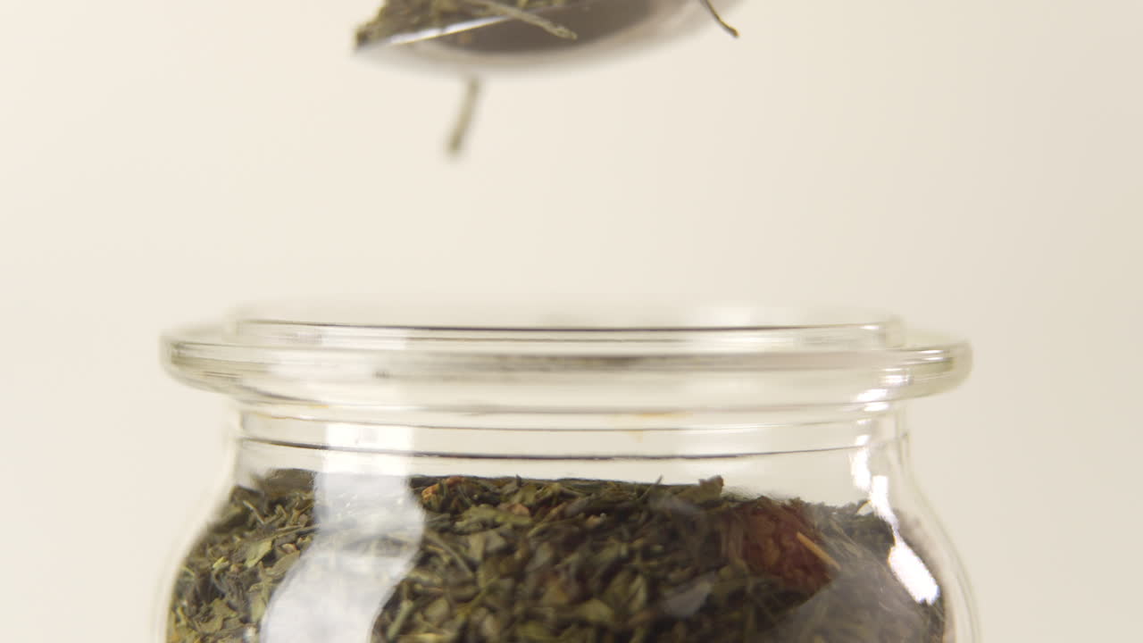 100fps로 유리병에서 녹차 잎 더미를 꺼내는 스푼의 측면 샷