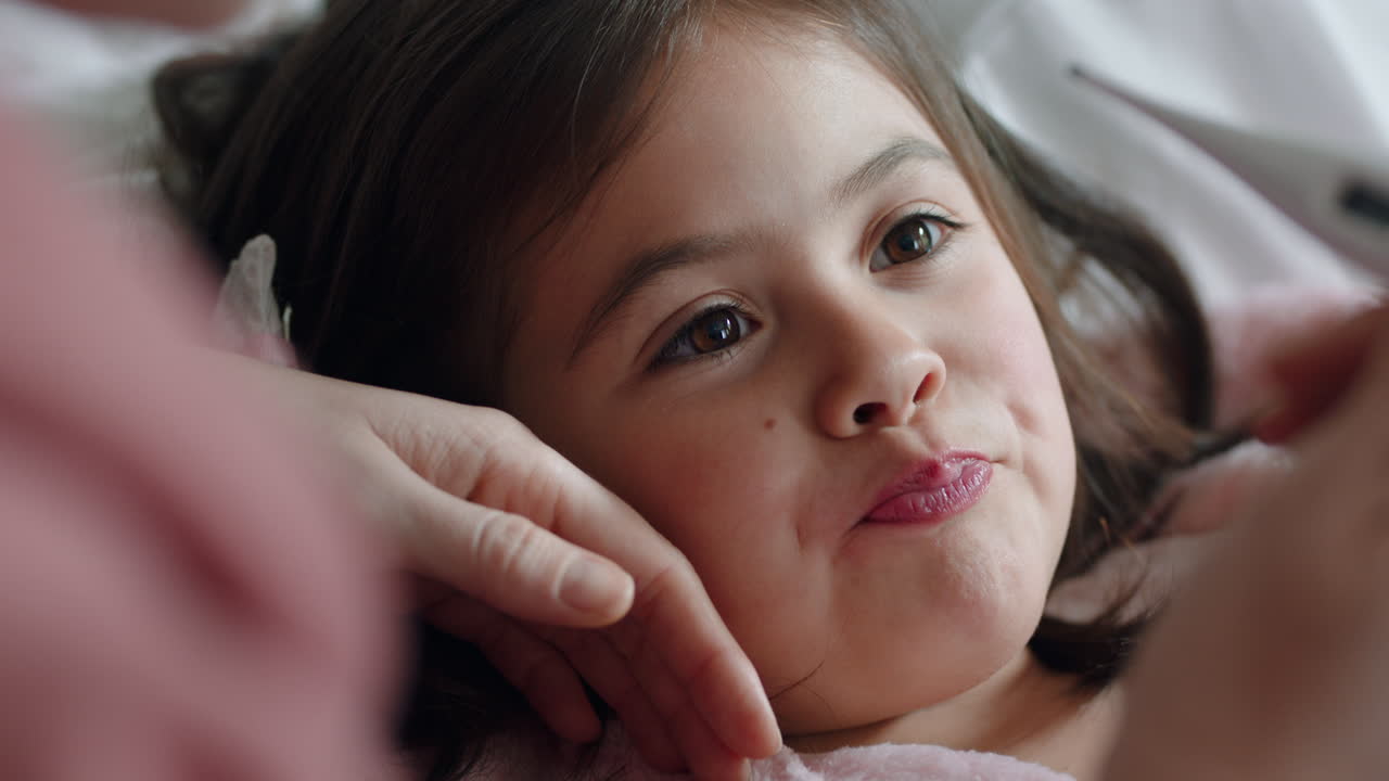madre cuidando a un niño enfermo acostado en la cama con gripe midiendo la temperatura usando un termómetro niña en casa con fiebre madre dando atención médica