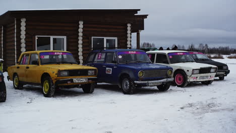 coches de rally vintage en el paisaje nevado