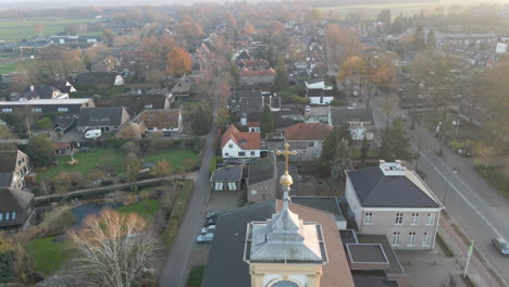 aerial-reveal-of-church-with-golden-crucifix-on-clock-tower