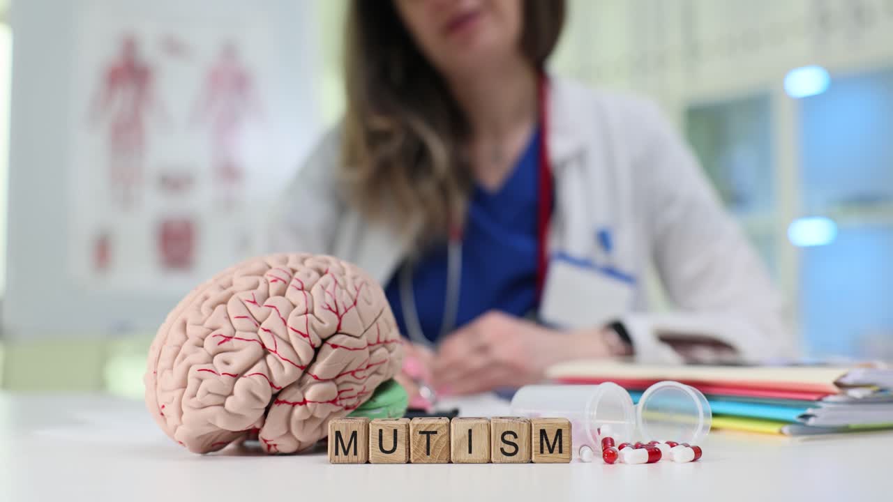 Mutism Word Blocks, Brain Model, and Pills on a Doctor's Desk