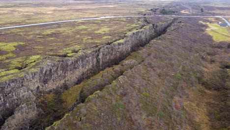 avión no tripulado volando sobre el cañón en el parque nacional de thingvellir, islandia, paisaje de otoño