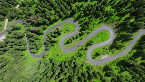 aerial top down of serpentine road near giau pass weaving through forested dolomites terrain
