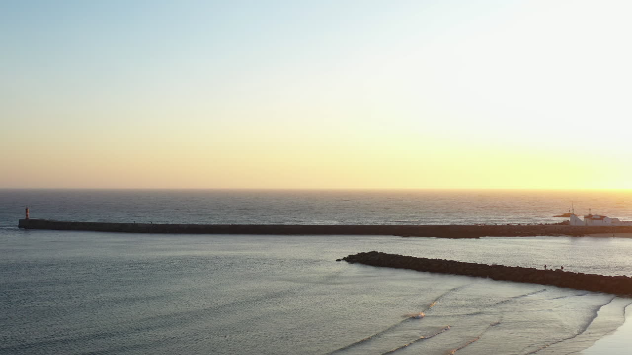 Aerial Track left shot of sunset over Azurara Breakwater, Portugal