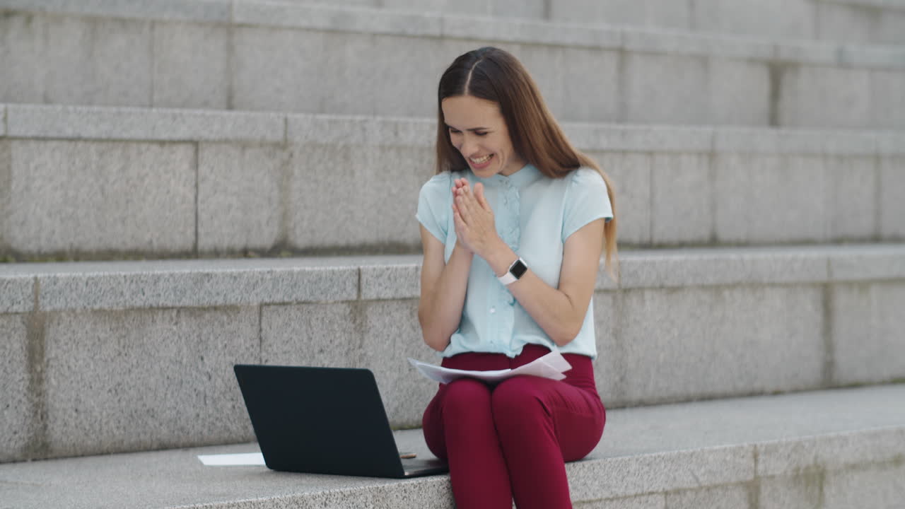 노트북에서 좋은 소식을 읽는 사업가. 야외에서 승리를 축하하는 매니저