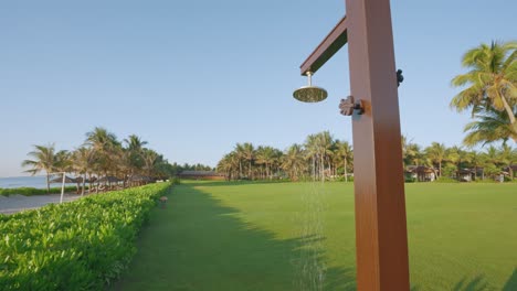 A-faucet-for-tourists-to-shower-after-swimming-on-the-beach-in-a-beautiful-landscape-at-a-tropical-resort-with-a-wide-angle-view